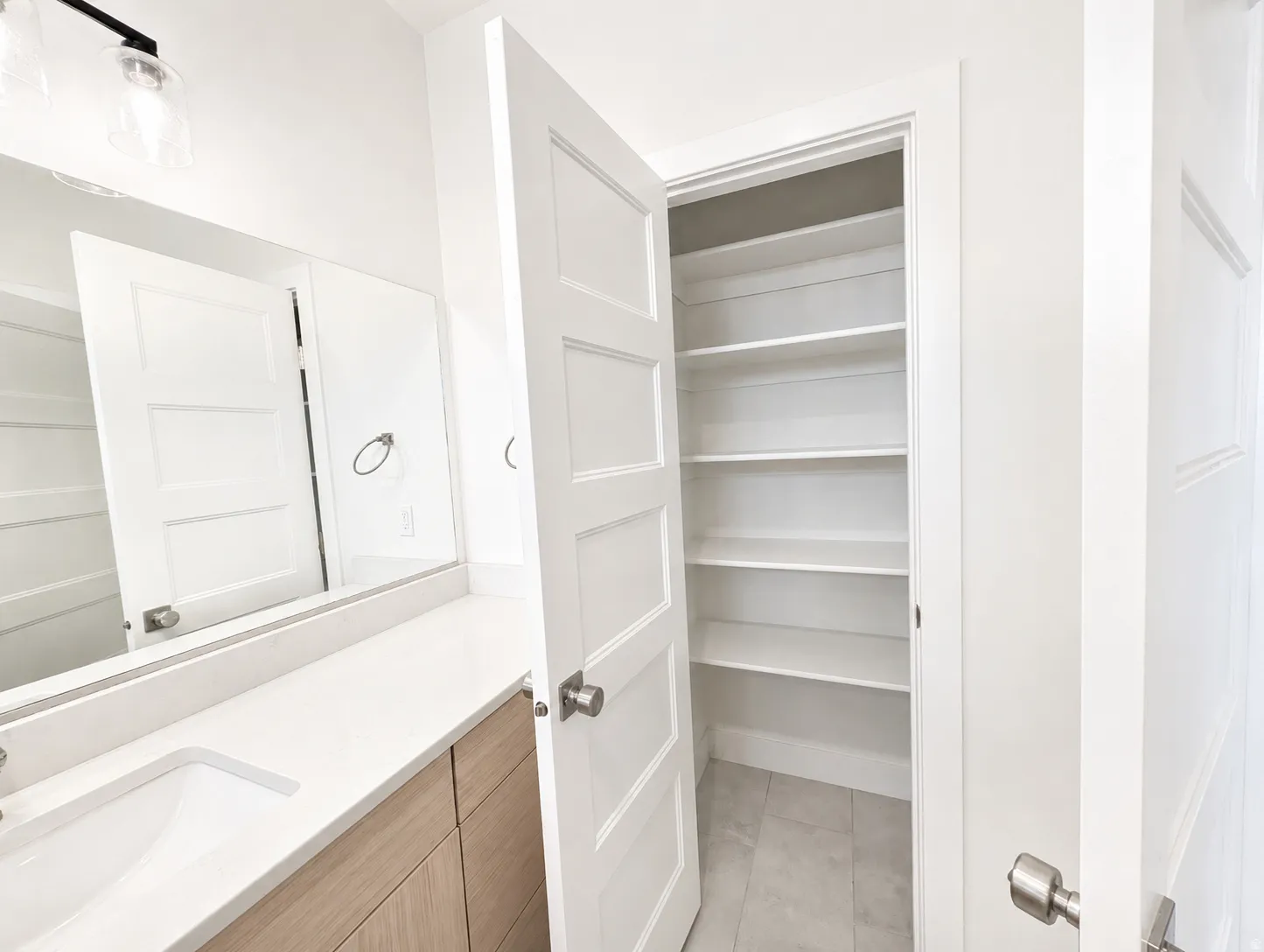 Bathroom featuring a wood-finish vanity with a white countertop and an undermount sink