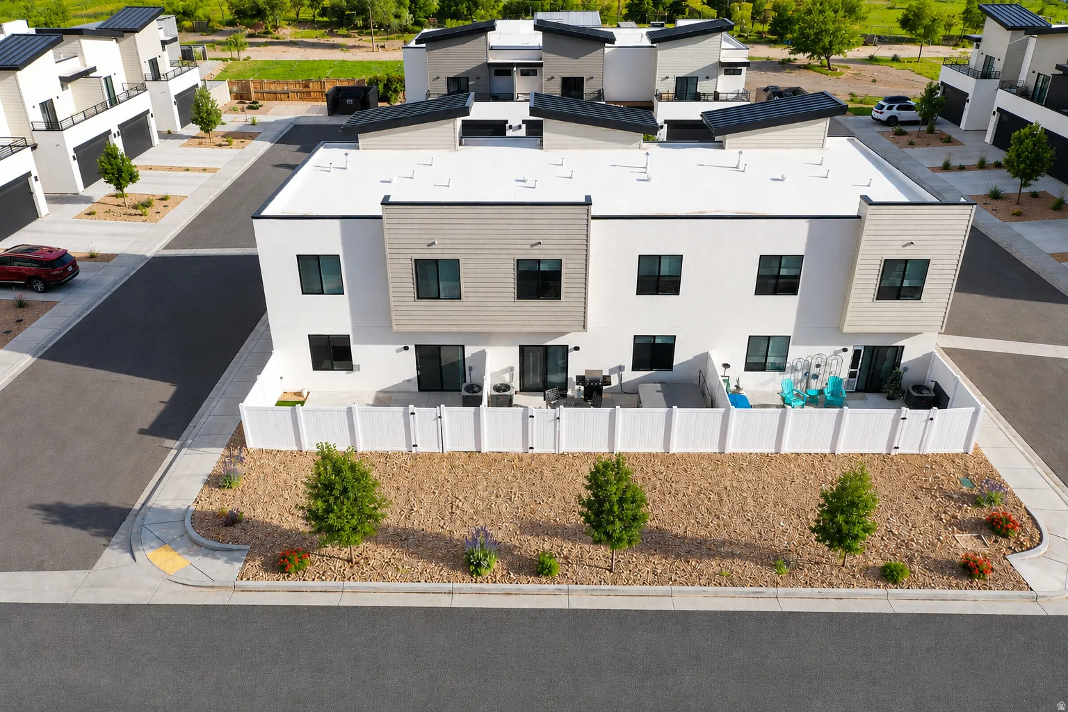 Contemporary townhome featuring a white stucco and horizontal siding exterior