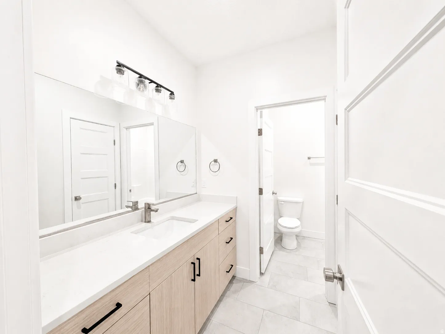 Light wood-finish vanity with a white countertop and rectangular undermount sink