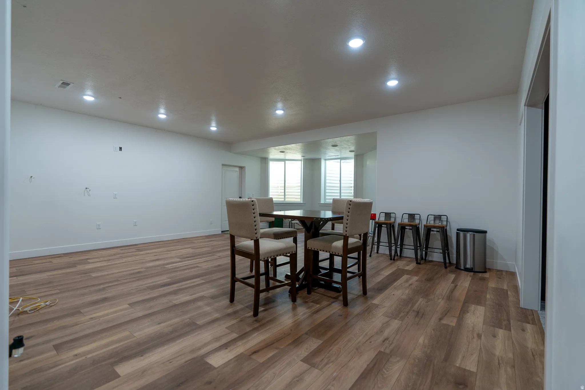 Spacious room featuring wood-finish flooring, recessed lighting, and a neutral color palette