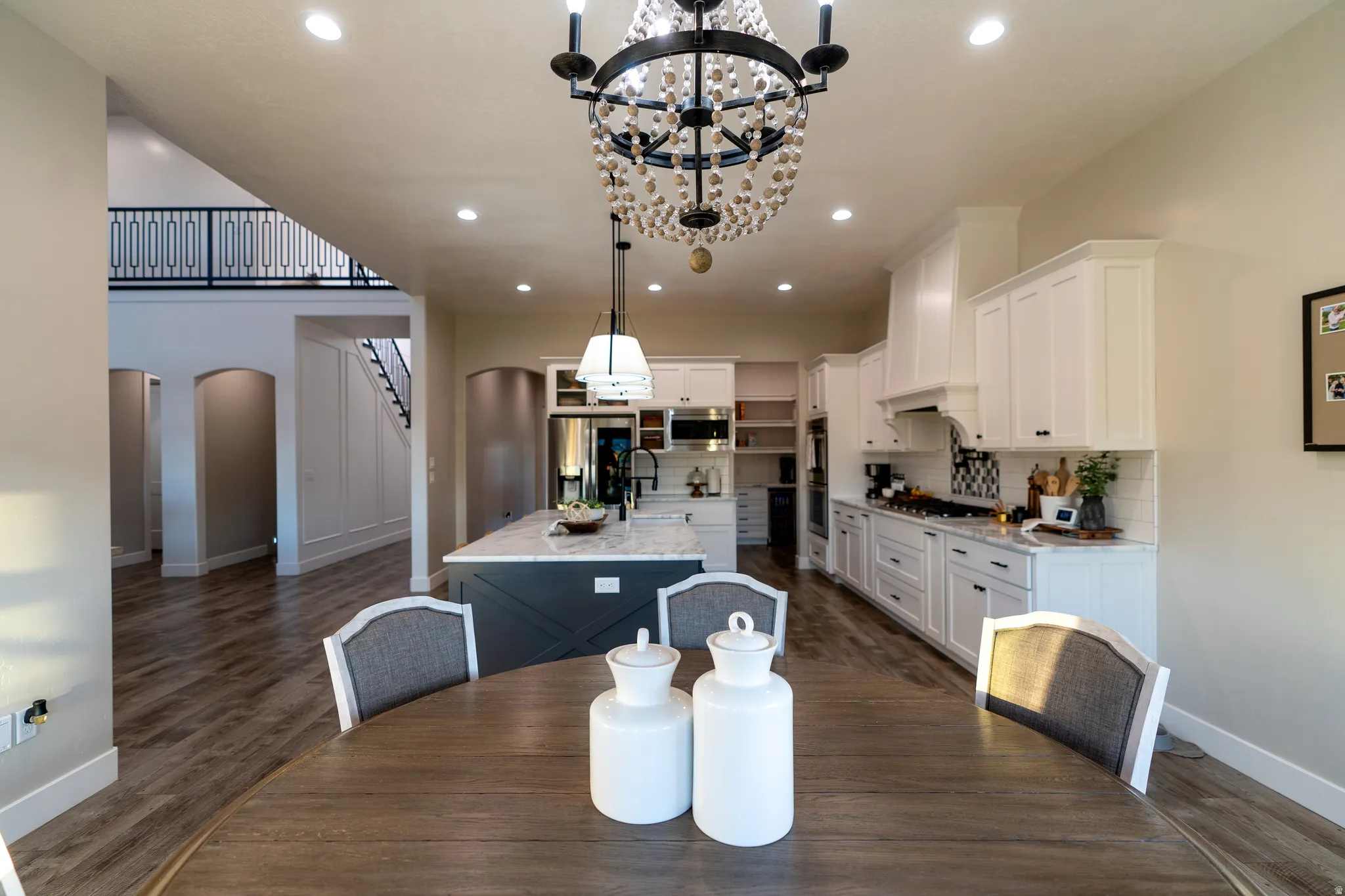 Kitchen featuring white shaker cabinetry, stainless steel appliances, a center island with a stone countertop, and wood-finish flooring