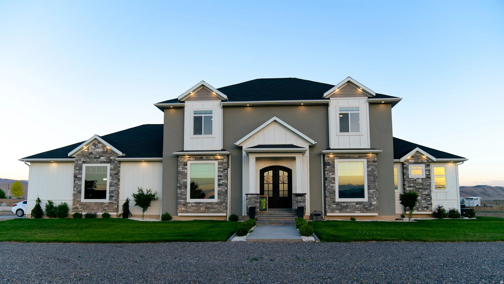Contemporary residence featuring a stucco and stone facade with board-and-batten accents