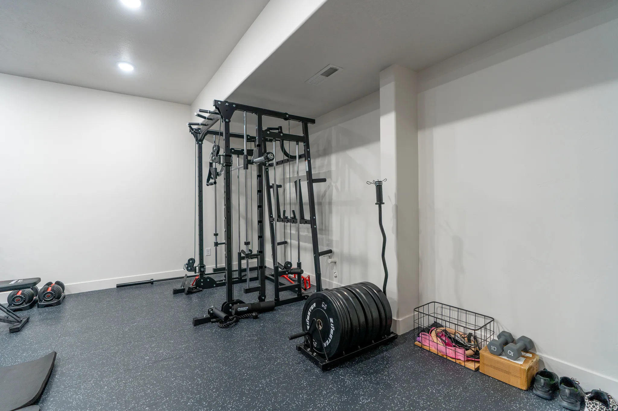 Dedicated fitness space featuring recessed lighting, a durable rubberized floor, and white walls