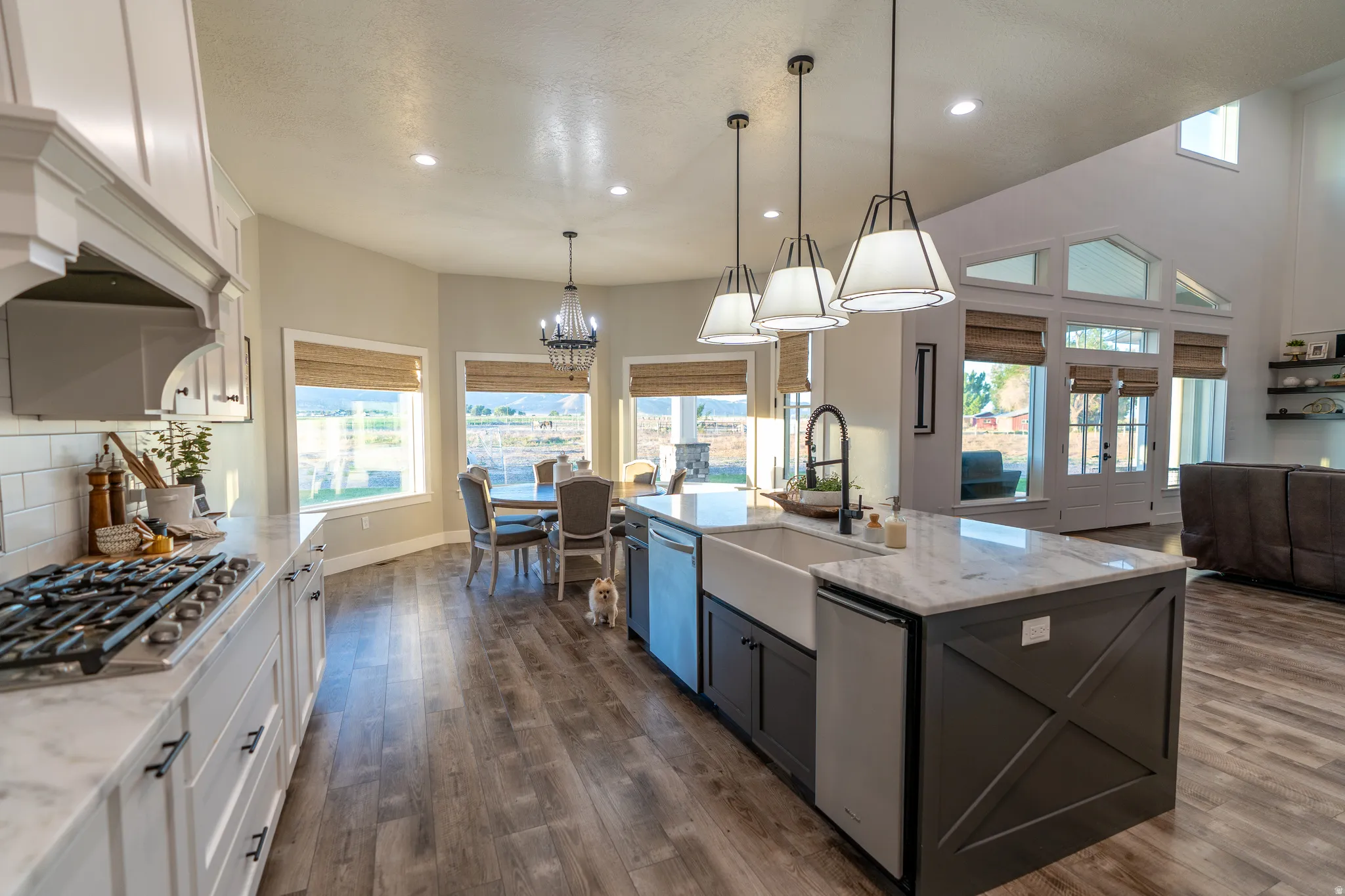 Open-concept kitchen with wood-finish flooring, white cabinetry, and light-toned countertops