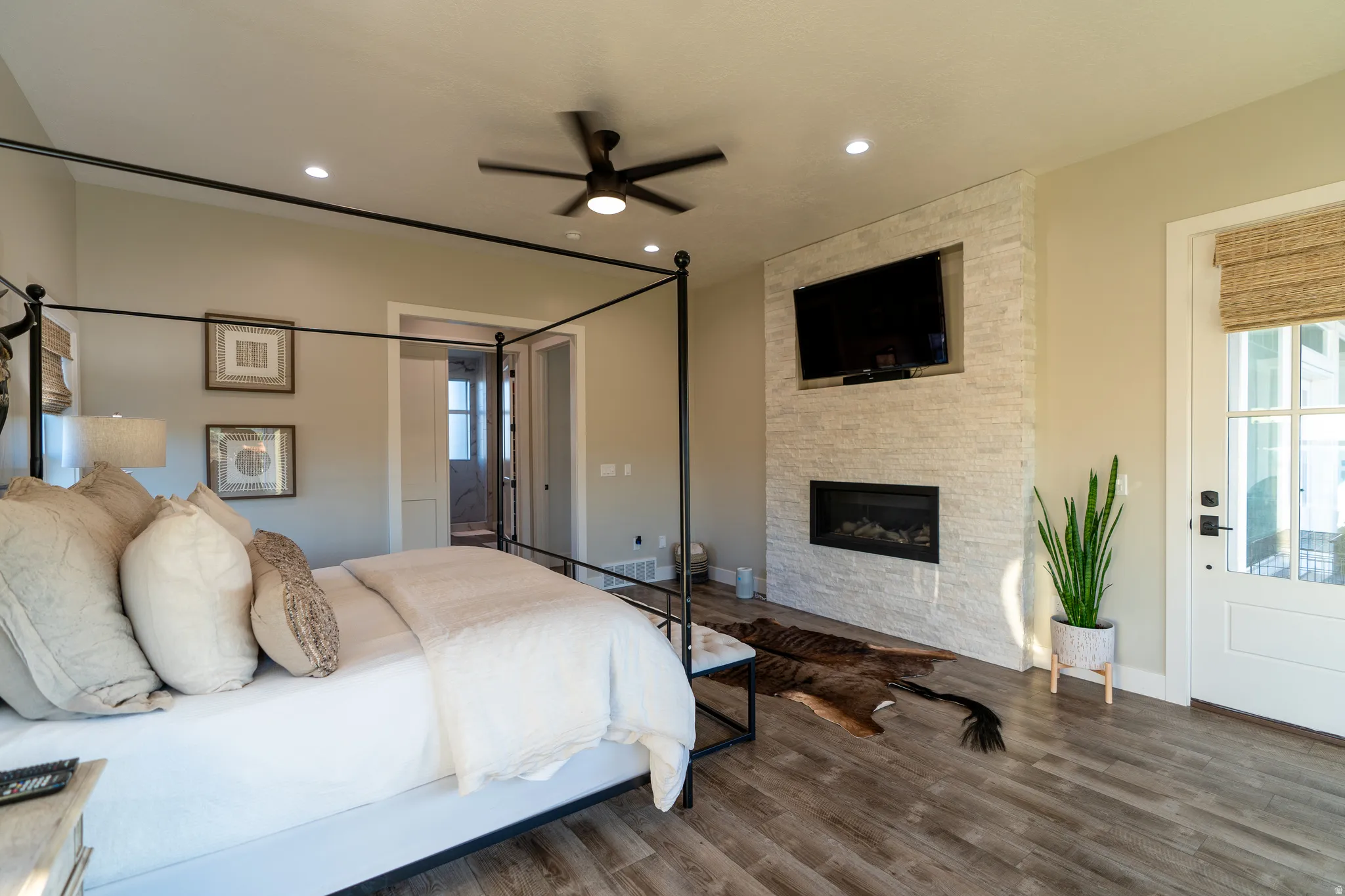 Spacious room featuring wood-finish flooring, a ceiling fan with integrated lighting, and recessed lighting