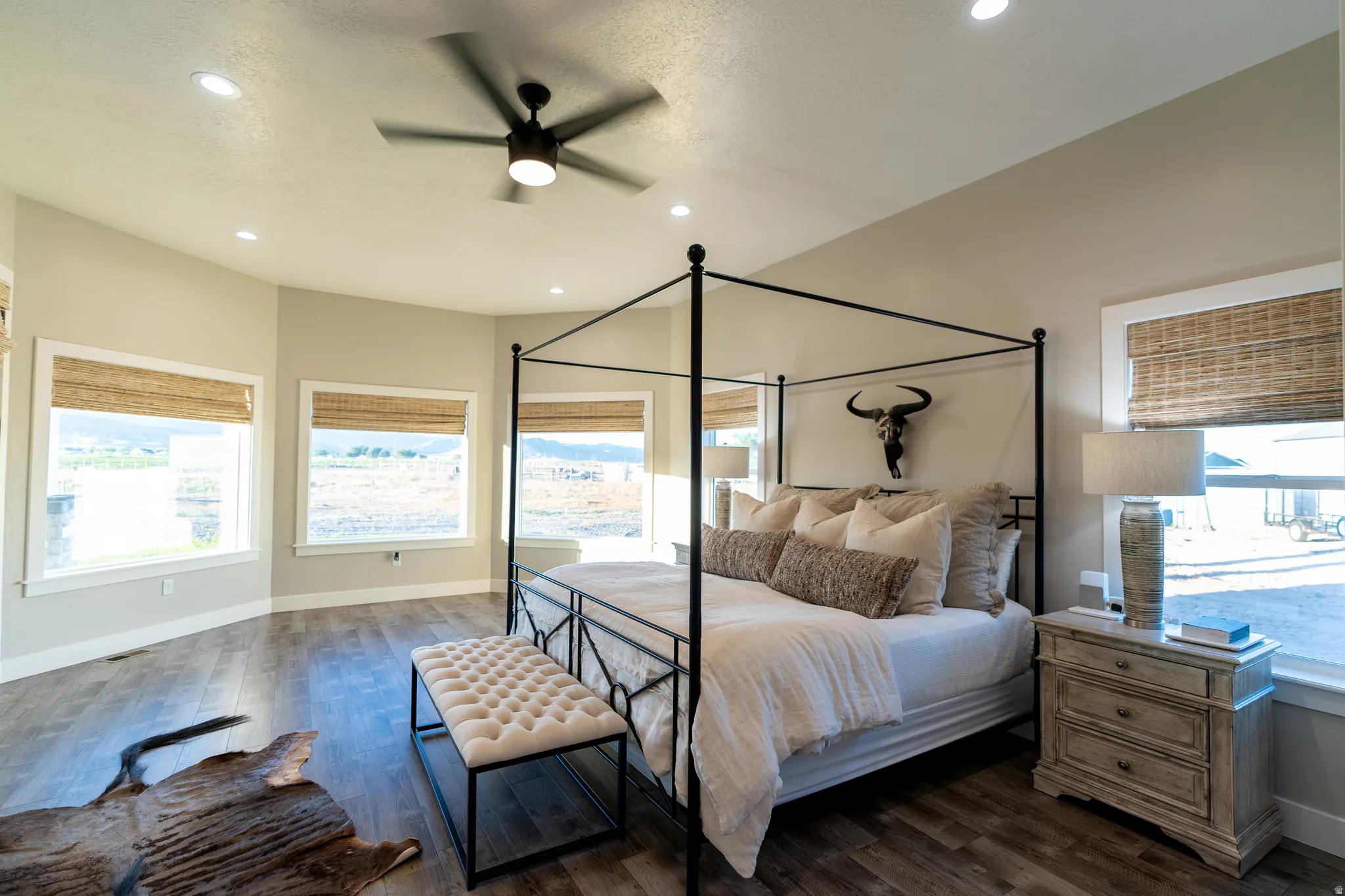 Spacious bedroom featuring wood-finish flooring, recessed lighting, and a contemporary ceiling fan