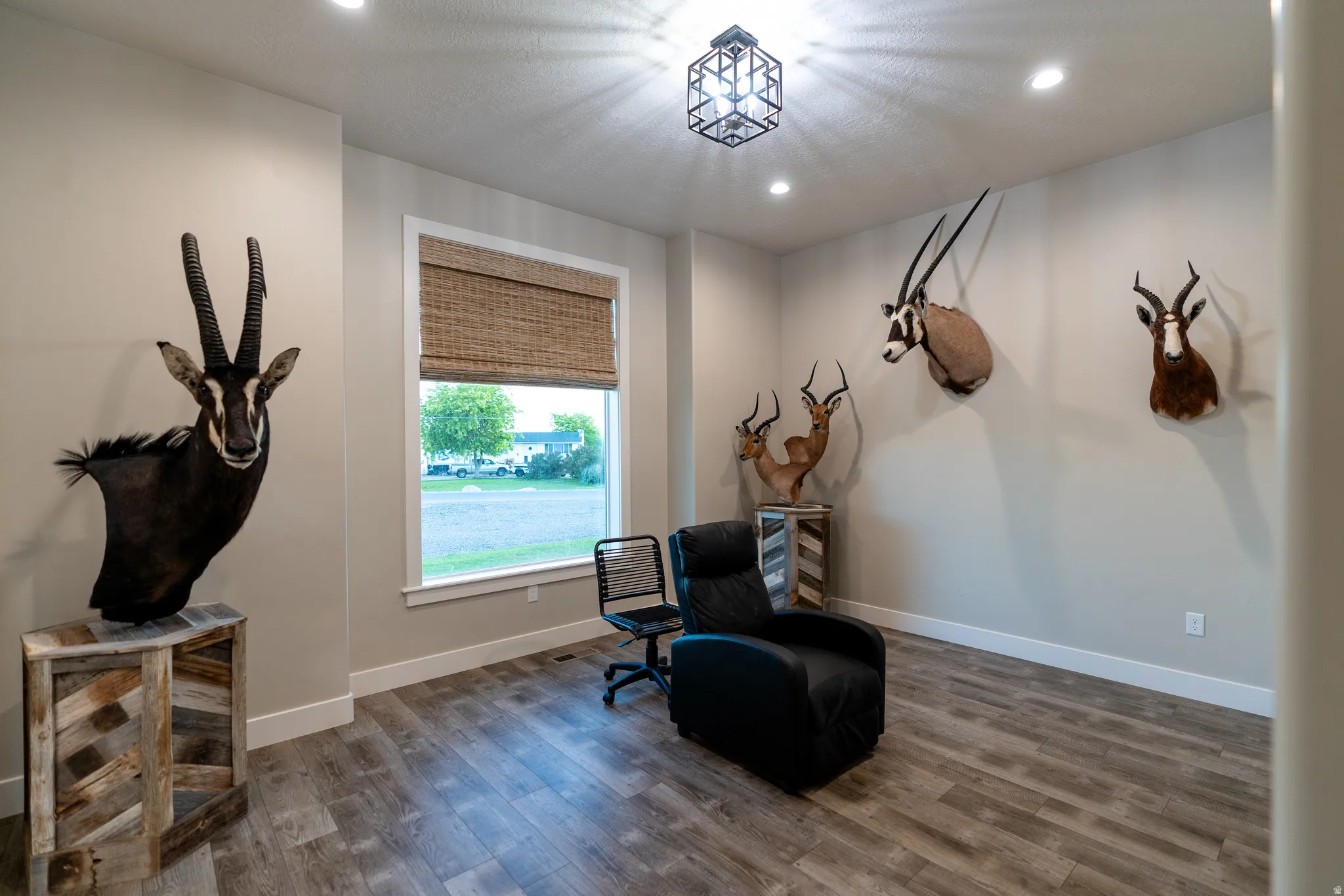 Spacious room with light-toned walls, wood-finish flooring, and recessed ceiling lighting
