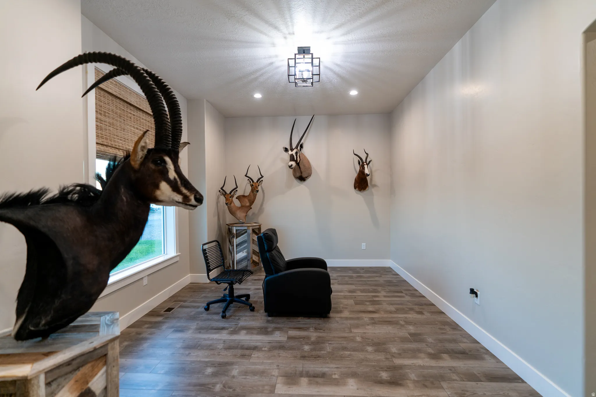 Spacious interior room featuring wood-finish flooring, recessed lighting, and a modern ceiling fixture