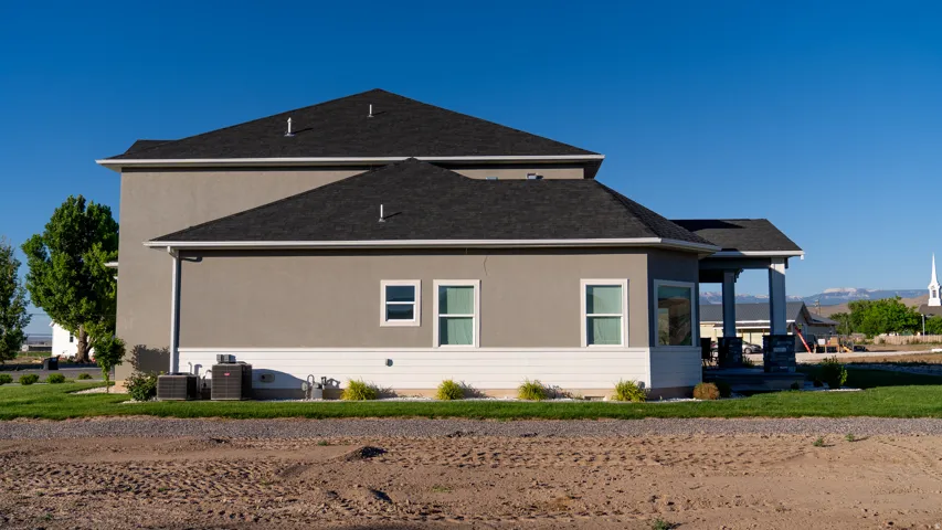 Modern stucco exterior with dark shingle roofing
