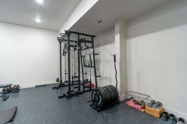Dedicated fitness space featuring recessed lighting, a durable rubberized floor, and white walls