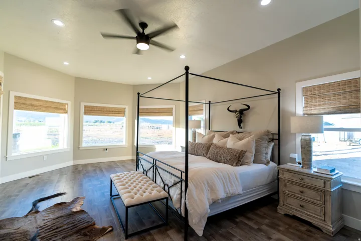 Spacious bedroom featuring wood-finish flooring, recessed lighting, and a contemporary ceiling fan