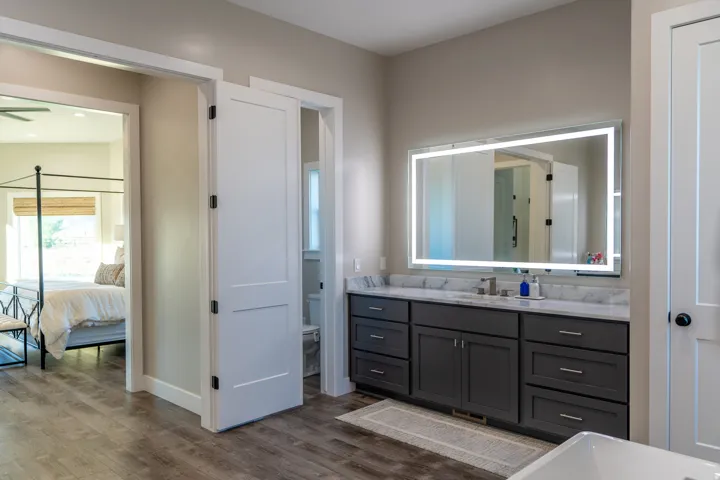 Bathroom vanity with a white countertop, undermount sink, and illuminated mirror