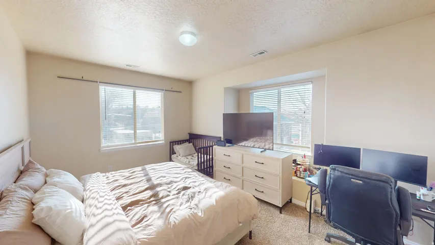 Carpeted room featuring two windows with blinds, a built-in window nook, and a flush-mount ceiling light fixture
