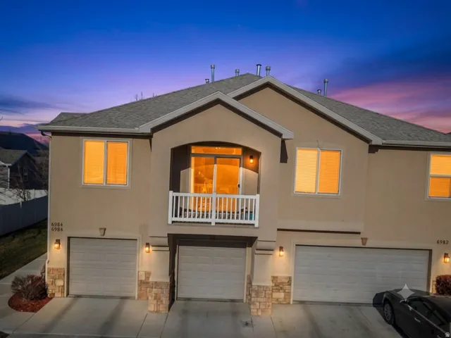 Multi-level stucco exterior with a gray shingle roof