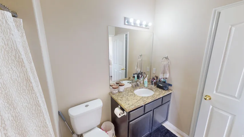 Bathroom vanity featuring an integrated sink, granite-style countertop, and dark wood-finish cabinetry