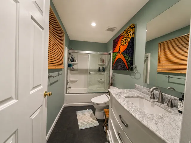 Bathroom featuring a white vanity with a light-toned countertop, an integrated sink, and brushed nickel fixtures