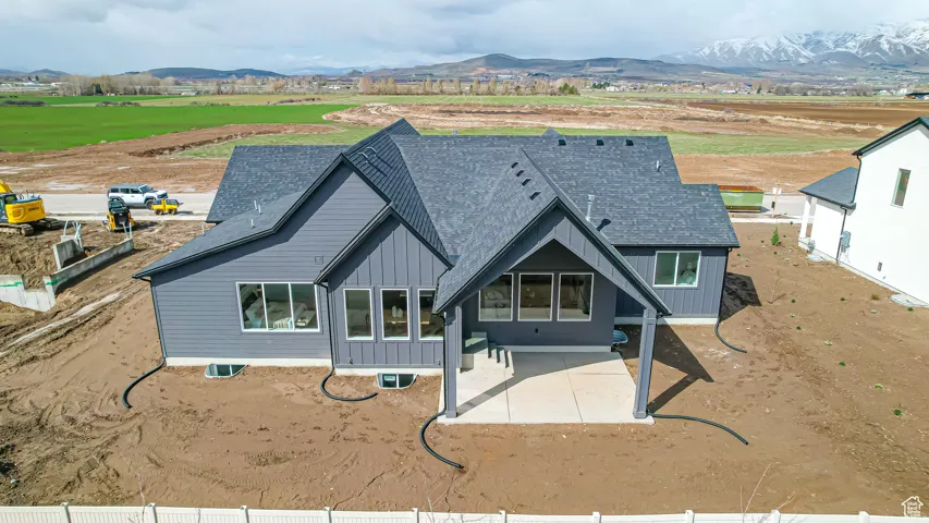 Rear elevation featuring dark gray siding and a covered patio with concrete flooring