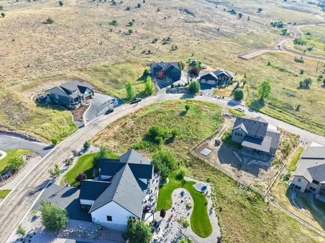 Expansive aerial view showcasing multiple properties within a developing hillside community