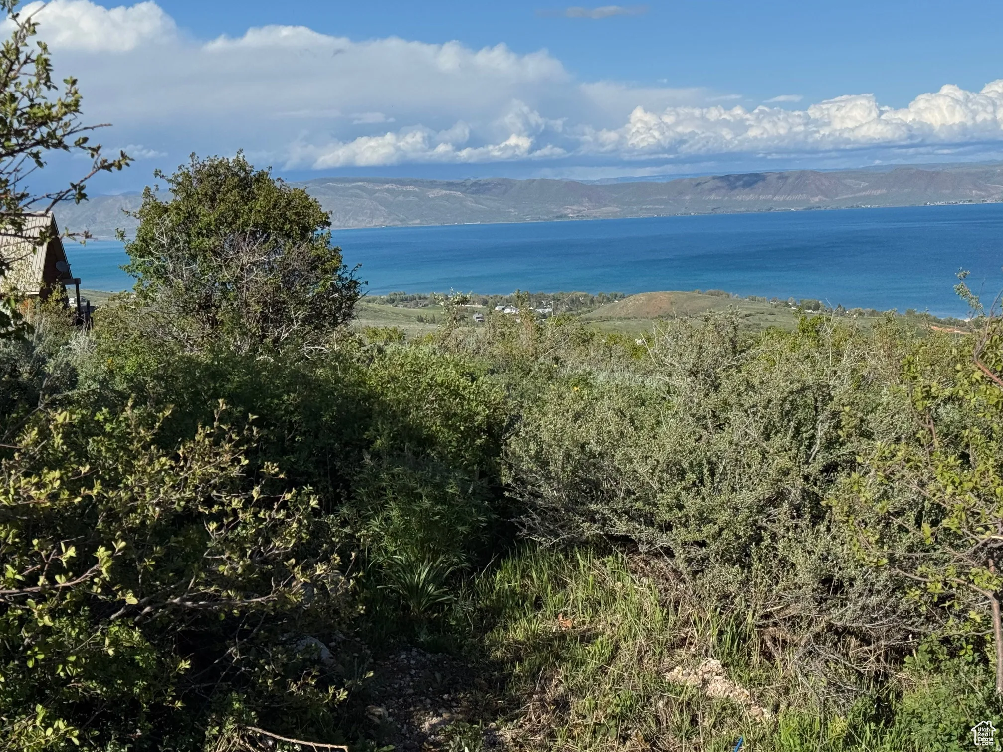 Expansive water body and distant hills under a partly cloudy sky