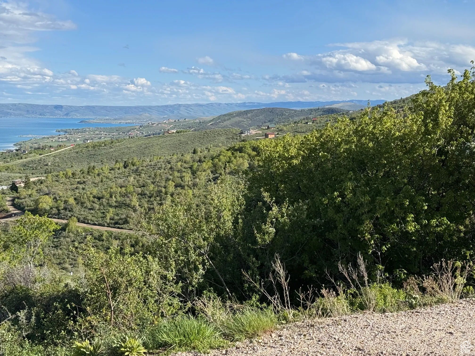 Expansive landscape featuring distant water and rolling hills