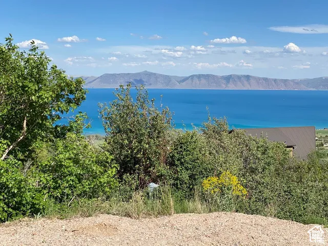 Expansive water body with distant mountains under a blue sky