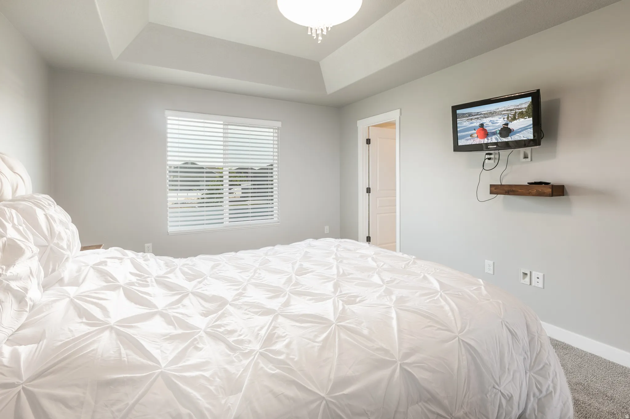 Tray ceiling with recessed lighting and a central flush-mount light fixture