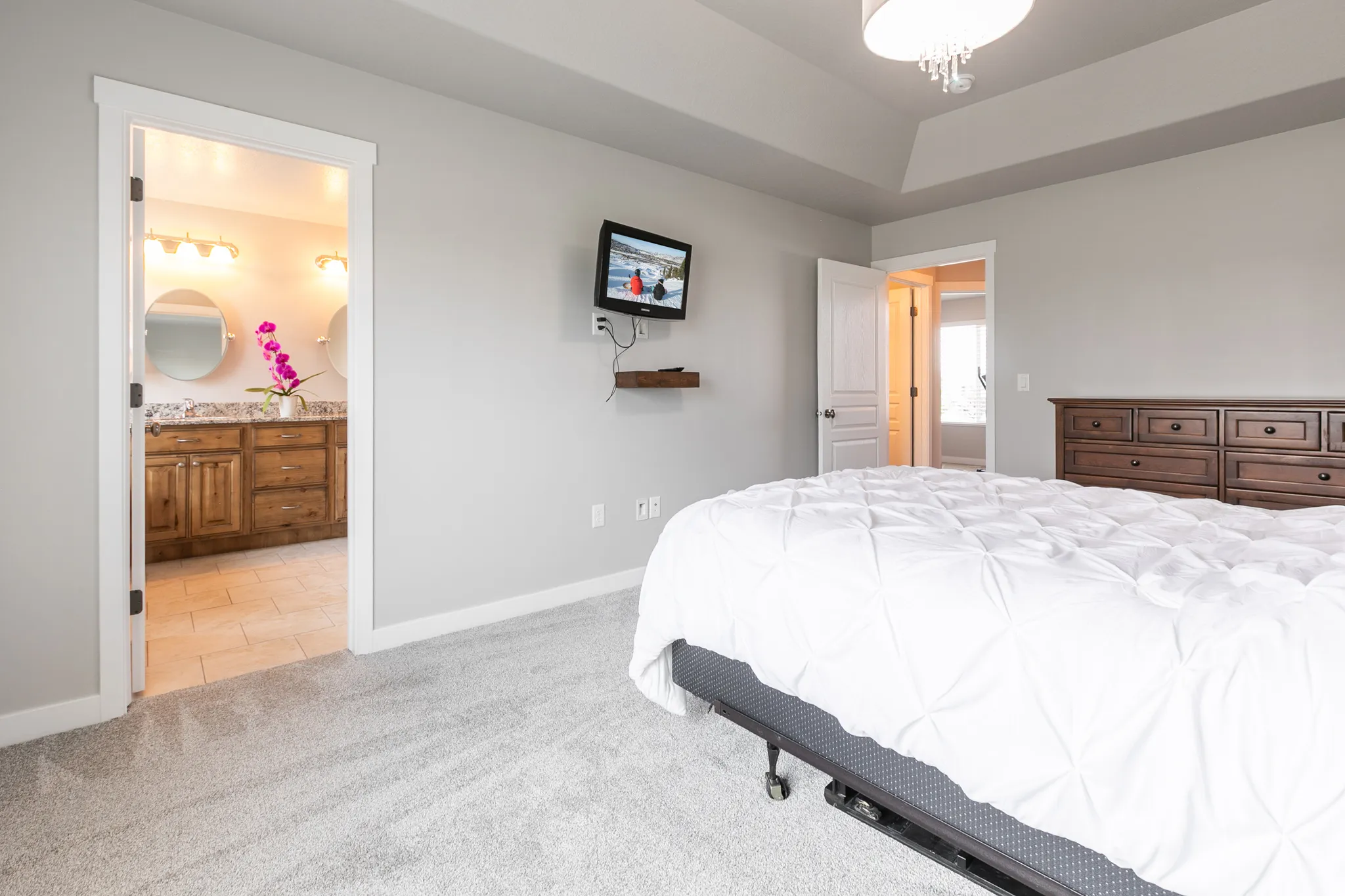 Carpeted room with tray ceiling and overhead light fixture