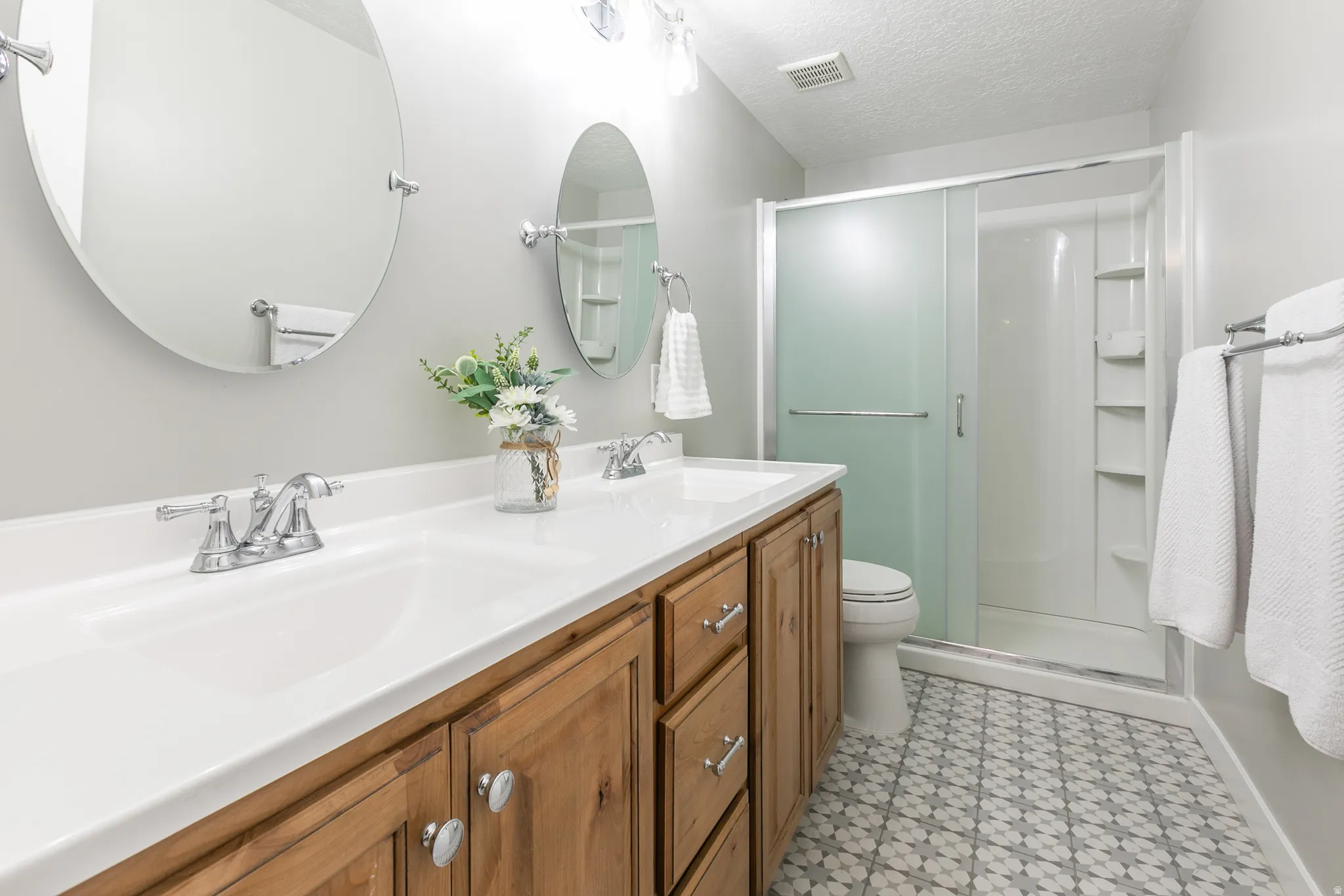 Dual vanity featuring integrated white sinks and wood-finish cabinetry