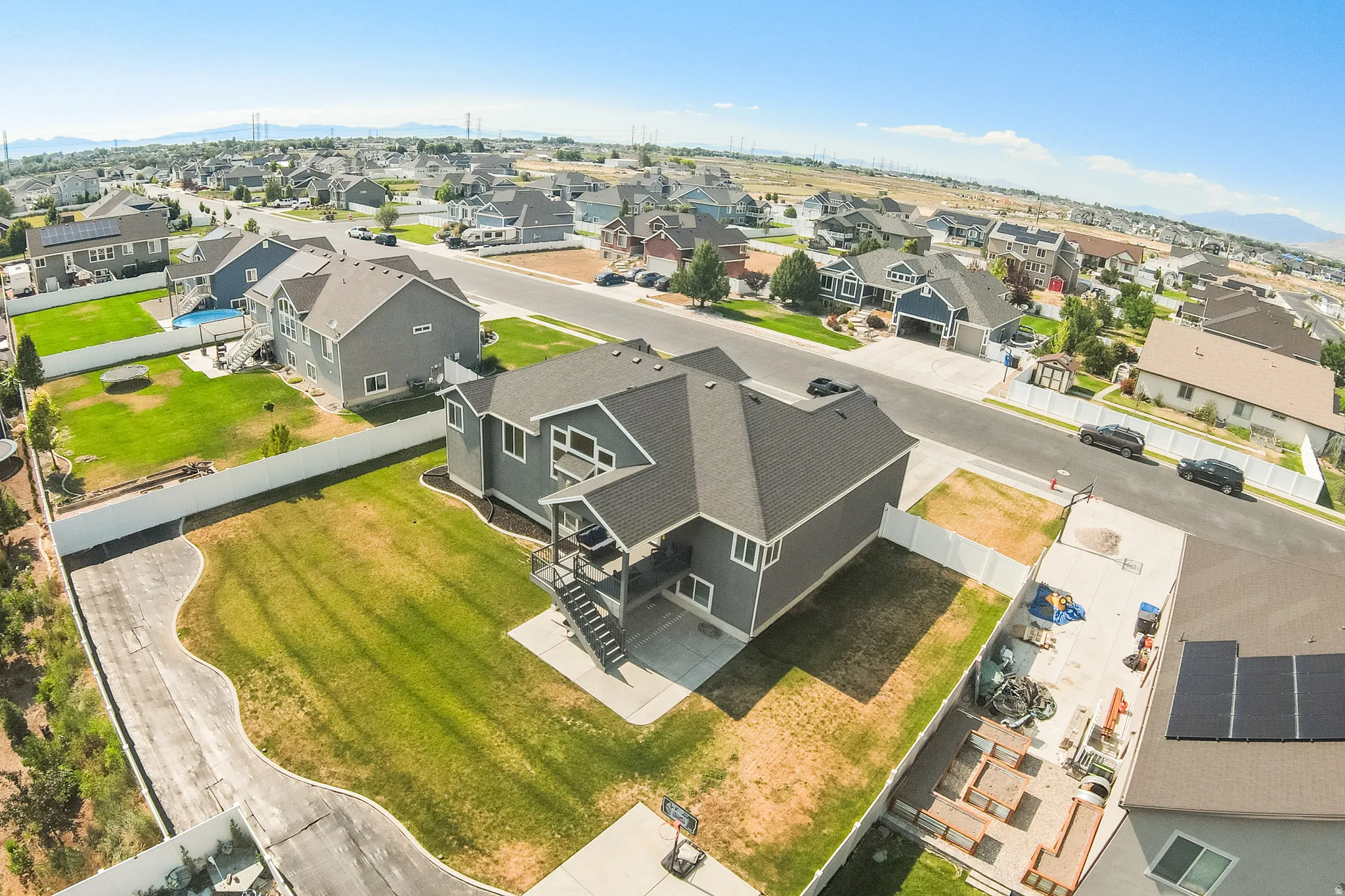 Two-story residential property with dark gray siding and a black shingled roof