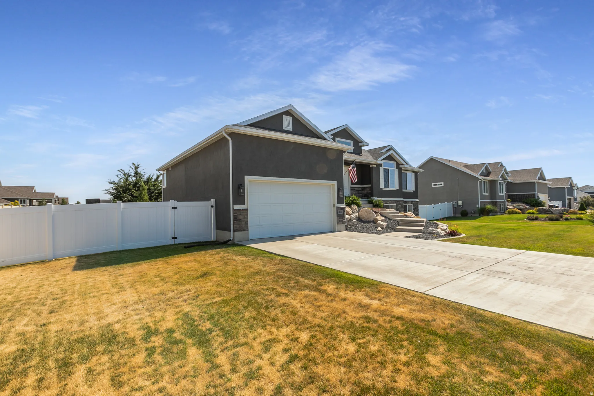 Gray stucco exterior with a prominent white garage door