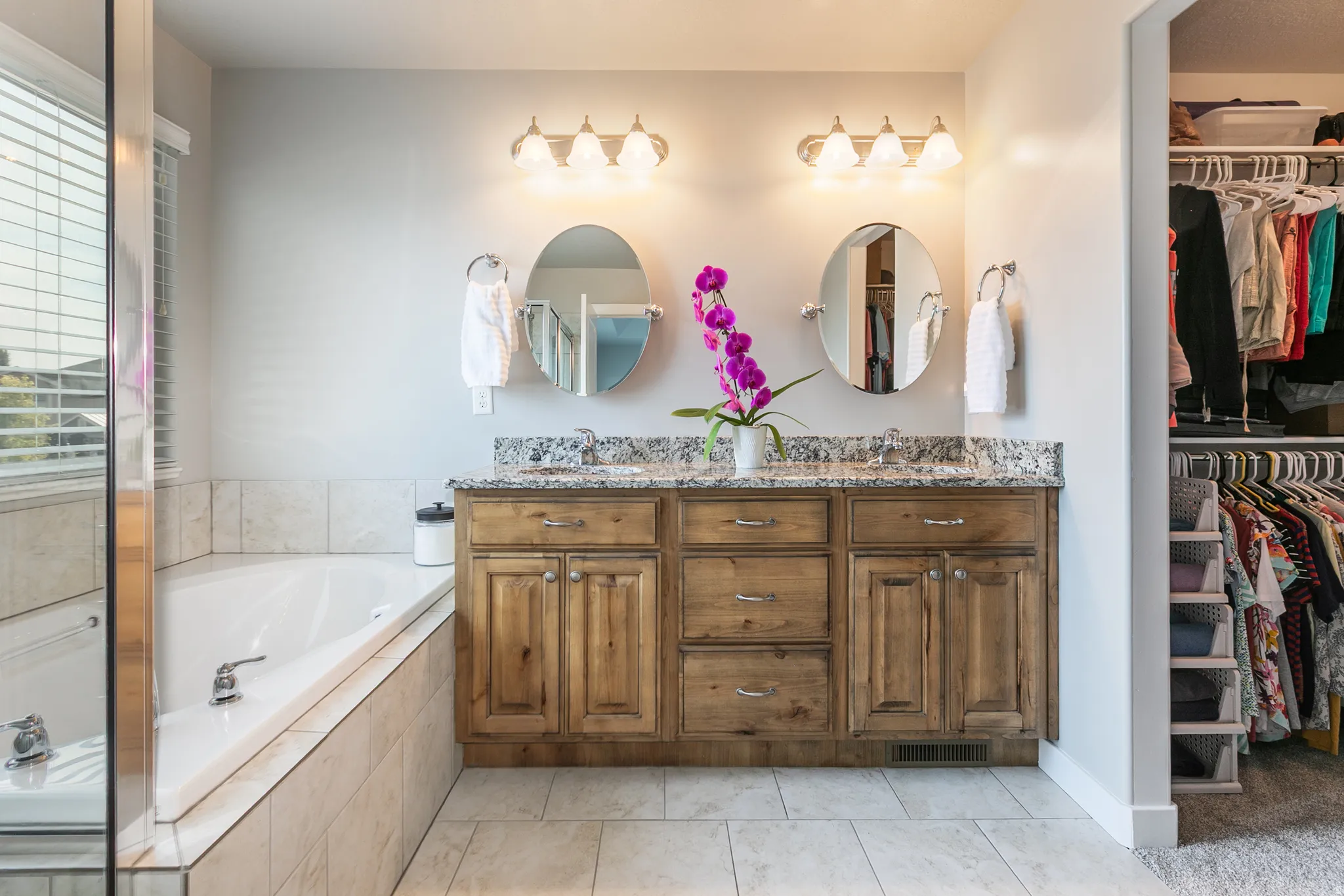 Dual vanity with granite countertop and wood-finish cabinetry