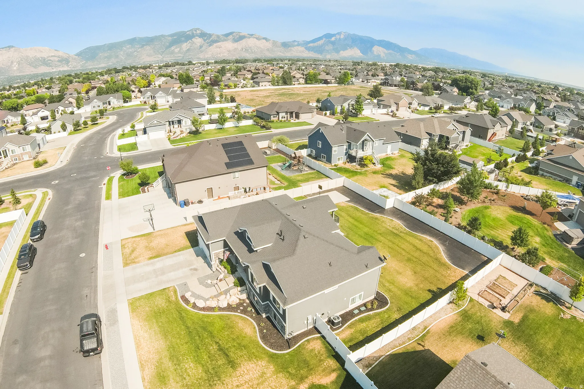 Residential neighborhood featuring established homes, paved streets, and mountain terrain in the background