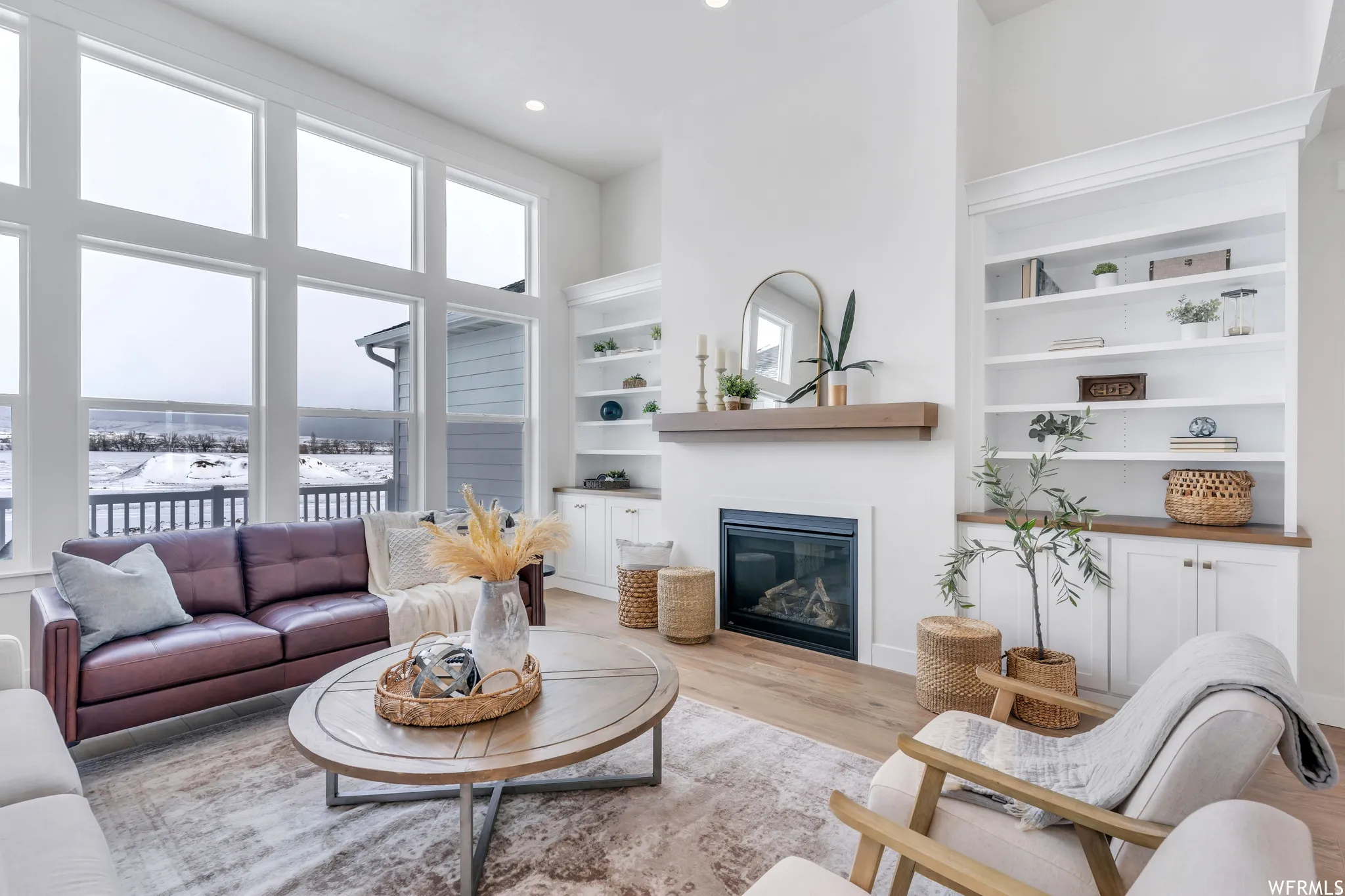 Family room has huge windows and built-ins on either side of the fireplace