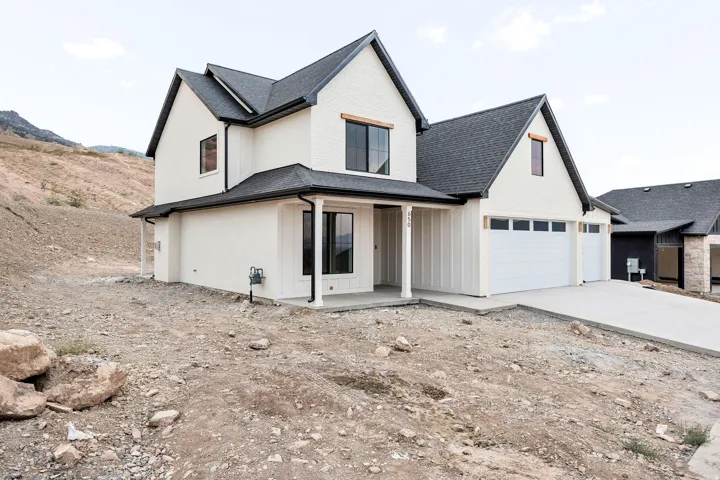 Modern farmhouse residence featuring a two-story design with gabled rooflines and dark charcoal shingles