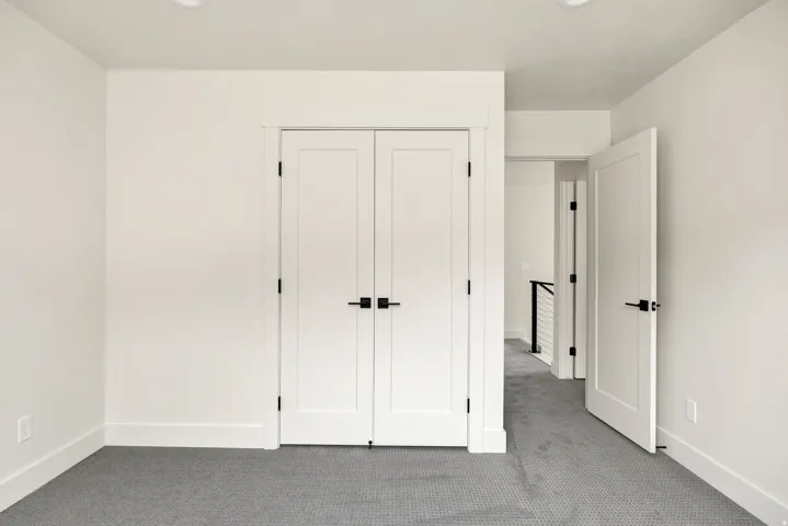 Recessed ceiling lighting, white interior doors, black hardware accents, and gray textured carpeting