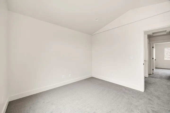 Carpeted room with a recessed light, crisp white walls, and white trim
