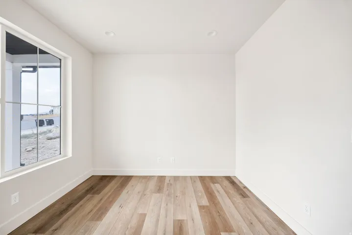 Recessed lighting, wood-finish flooring, and white walls