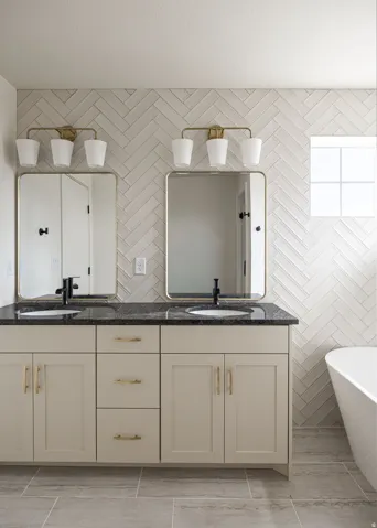 Dual vanity with dark countertops and gold-toned hardware