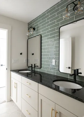 Dual vanity with black countertops and integrated sinks, complemented by light cabinetry with gold-tone hardware