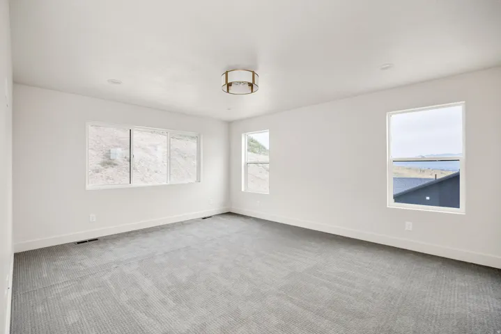 Recessed lighting, drum ceiling fixture, multiple windows, and neutral carpeting