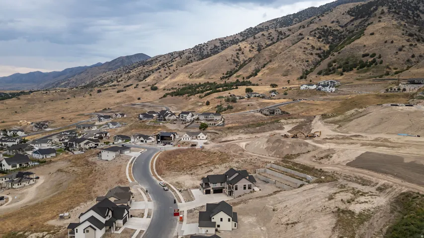 Residential development with a paved cul-de-sac and newly constructed homes, set against a mountainous backdrop