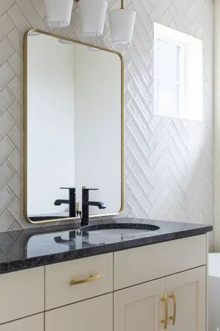 Vanity with a dark countertop, undermount sink, and matte black faucet