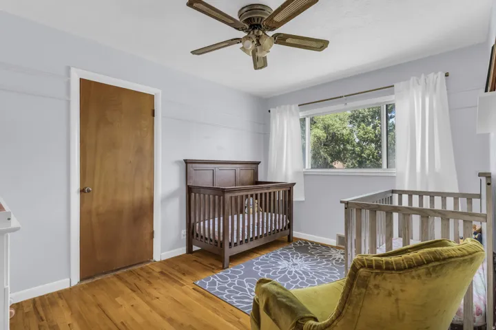 Light blue walls and wood-finish flooring complement the natural light from the large window