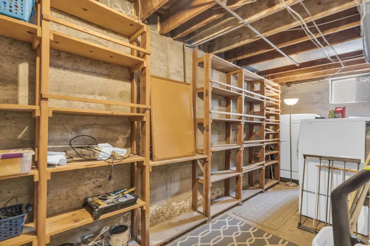 Extensive wood shelving provides ample storage against concrete walls