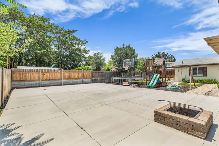 Expansive concrete patio area with a built-in stone block fire pit