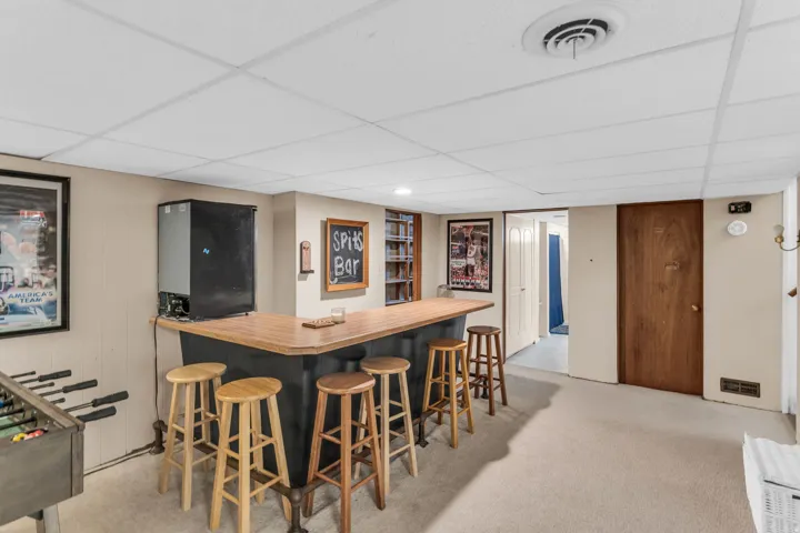 Finished basement featuring a built-in bar with a solid wood countertop and integrated cabinetry