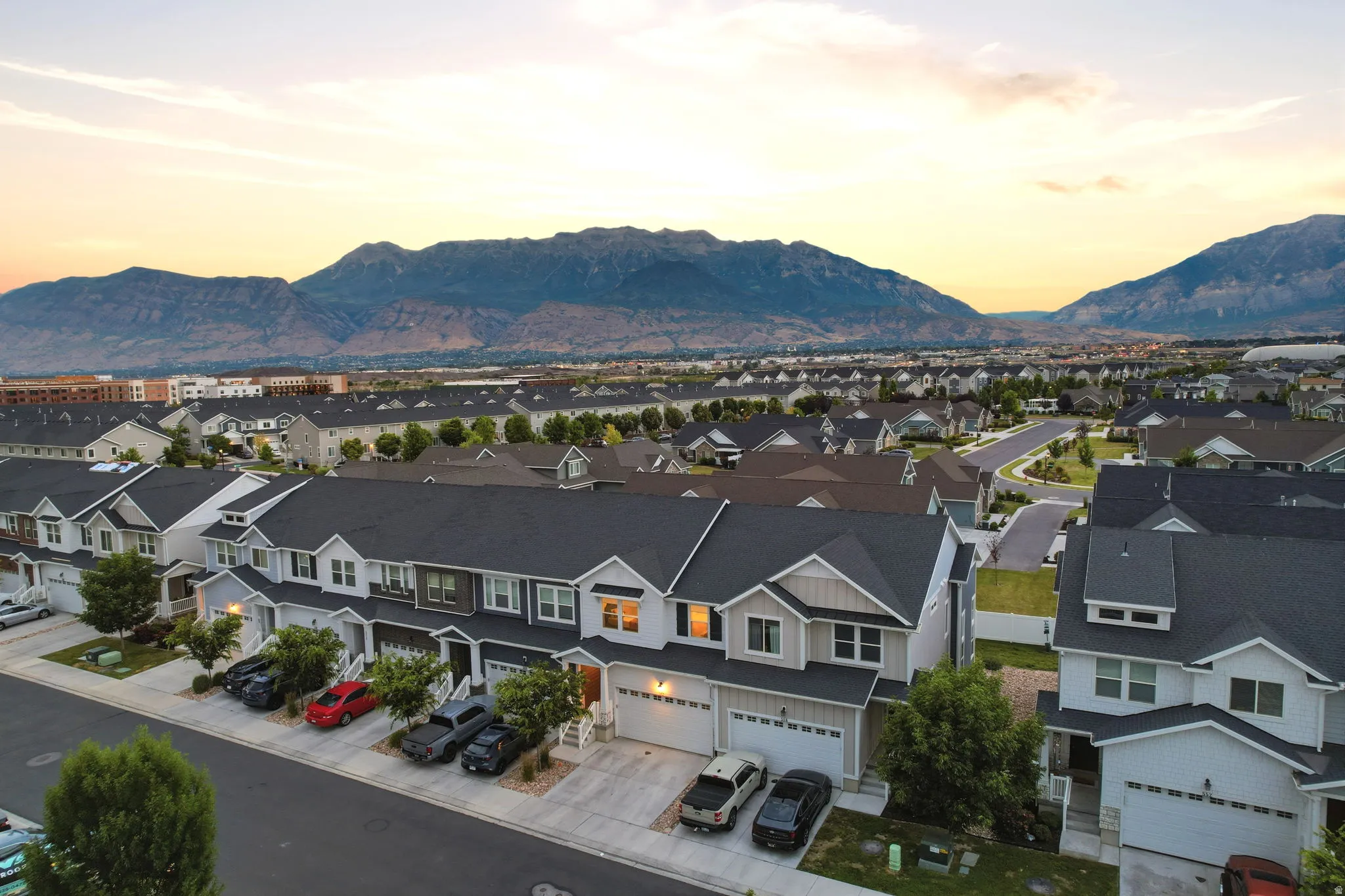 Modern residential community featuring two-story townhomes with dark shingle roofs and light-colored siding