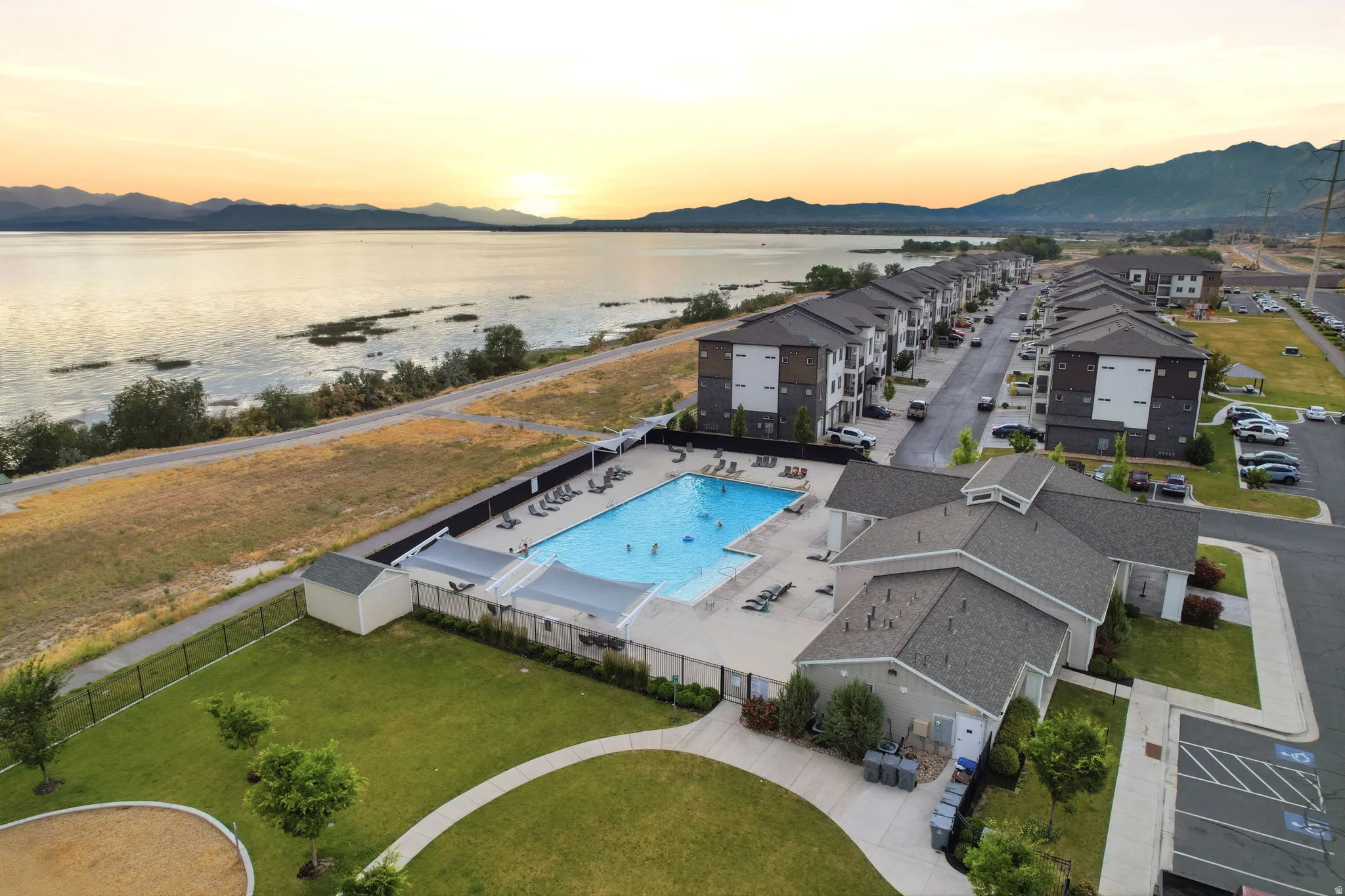 Community swimming pool with surrounding lounge areas and shade structures