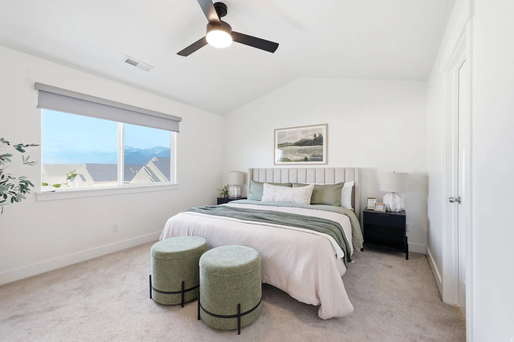 Vaulted ceiling bedroom with a wide window, carpeted flooring, and a modern ceiling fan
