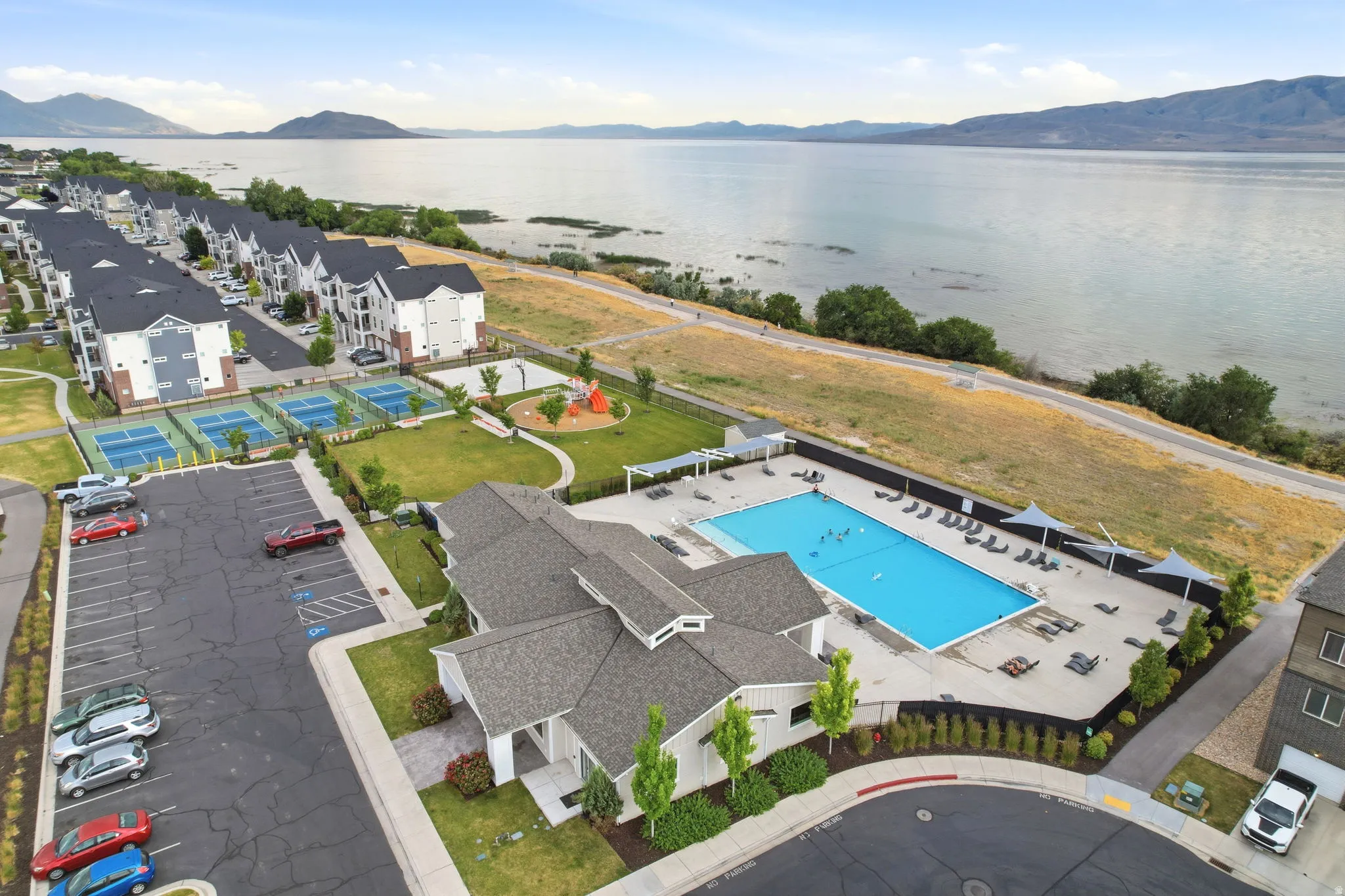 Community amenities including a swimming pool with lounge area, multiple tennis courts, and a playground